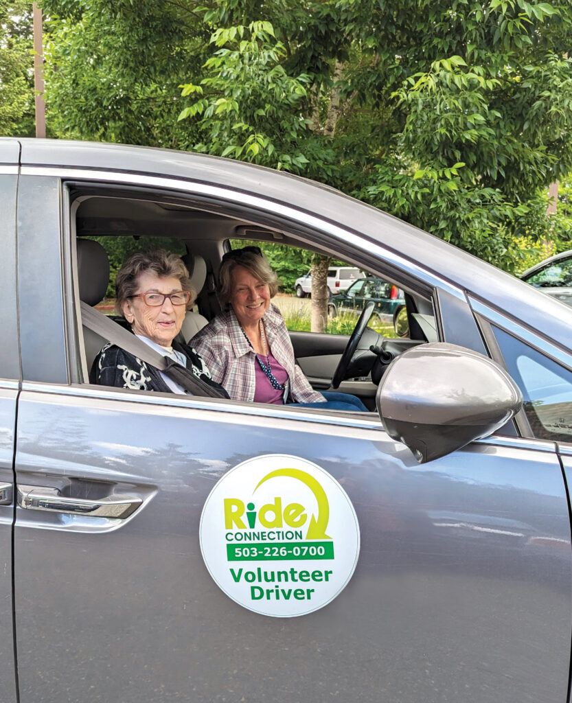 A female Ride Connection volunteer and an older female customer sit in a silver vehicle